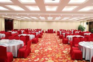 une grande salle de banquet avec des chaises et des tables rouges dans l'établissement Madison Lanzhou Lanshi Zhongchuan Airport, à Hejialiang
