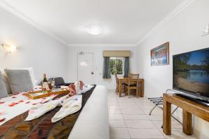 a living room with a couch and a flat screen tv at Point Samson Resort in Point Samson