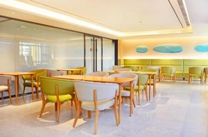 una sala da pranzo con tavoli e sedie di Ji Hotel Ulanqab Victoria Square a Jining