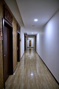 pusty korytarz z białymi ścianami i drewnianymi podłogami w obiekcie The Sato hotel w mieście Kudus