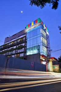 wysoki budynek z kolorowymi oknami i ulicą w obiekcie The Sato hotel w mieście Kudus