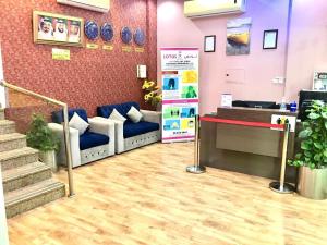 Lotus Furnished Hotel Apartments LLC. Ajman في عجمان: غرفة انتظار مع كنب ومكتب في مخزن