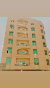 un grand bâtiment avec des fenêtres et des balcons. dans l'établissement Lotus Furnished Hotel Apartments LLC. Ajman, à Ajman