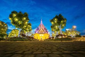 un edificio iluminado con árboles delante de él en B2 Khon Kaen Premier Hotel en Ban Si Than