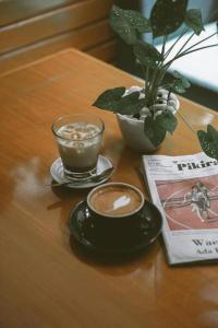 uma mesa com duas chávenas de café e um livro em The Priangan Hotel @ Sudirman em Nagrak