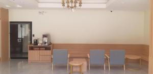 a dining room with four chairs and a table at Ceniq Hotel in Lampang
