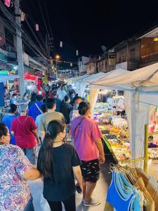 Ban Nam Phung的住宿－นิวธาราเพลส หล่มสัก โรงแรม，一群人晚上在市场里走来走去