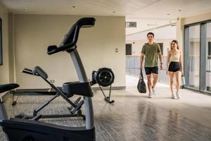 a man and woman walking in a gym with a treadmill at 1521 Hotel Mactan in Mactan