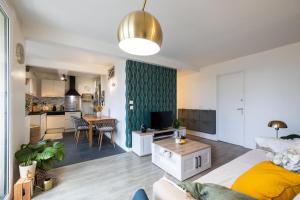 ein Wohnzimmer und eine Küche mit einem Bett und einem Tisch in der Unterkunft Appartement cosy et lumineux-parking gratuit- proche de Paris in LʼHay-les-Roses