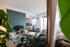 sala de estar con sofá y TV en Appartement cosy et lumineux-parking gratuit- proche de Paris en LʼHay-les-Roses