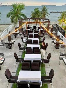 una fila de mesas y sillas en una playa en THE SHORELINE SUBIC HOTEL, en Olóngapo