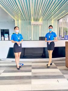two women wearing face masks standing in a room at THE SHORELINE SUBIC HOTEL in Olongapo