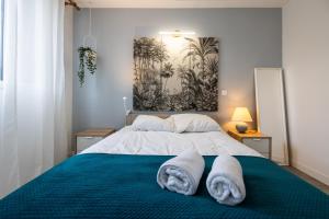 1 dormitorio con 1 cama con 2 toallas en Appartement cosy et lumineux-parking gratuit- proche de Paris en LʼHay-les-Roses