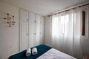 Un dormitorio con una cama con dos zapatos blancos. en Appartement cosy et lumineux-parking gratuit- proche de Paris en LʼHay-les-Roses