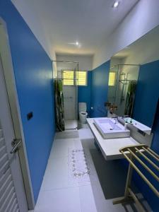 a blue bathroom with a sink and a toilet at Baan Bangrak Garden in Koh Samui