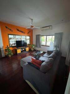 een woonkamer met een bank en een tv bij Baan Bangrak Garden in Koh Samui 
