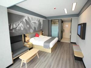 a bedroom with a bed and a couch and a tv at Thank Hotel Shanxi Lvliang Zhongyang County North Fengcheng Street in Zhongyang