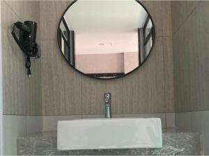 a sink in a bathroom with a mirror at Thank Hotel Shanxi Lvliang Zhongyang County North Fengcheng Street in Zhongyang