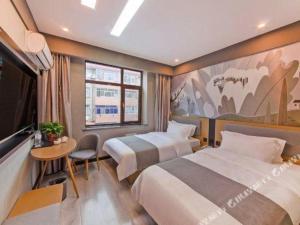 um quarto de hotel com duas camas e uma televisão em Thank Hotel Hebei Cangzhou Wuqiao County Acrobatics World em Wuqiao