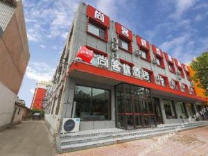 een gebouw met een bord aan de voorkant bij Thank Hotel Hebei Cangzhou Wuqiao County Acrobatics World in Wuqiao