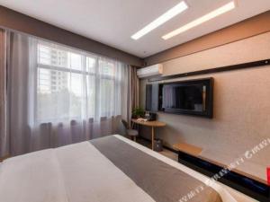 een hotelkamer met een bed en een televisie bij Thank Hotel Hebei Cangzhou Wuqiao County Acrobatics World in Wuqiao