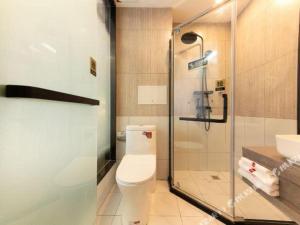 een badkamer met een toilet en een glazen douche bij Thank Hotel Hebei Cangzhou Wuqiao County Acrobatics World in Wuqiao