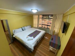 een slaapkamer met een groot bed en een raam bij Wayra Hotel in Huaraz