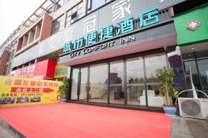 a store with a red carpet in front of a building at City Comfort Inn Luzhou Jiangyang District Wancheng International in Luzhou