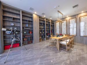 a room with a camera and a table and shelves at Echarm Hotel Hanzhong Wetland Park in Hanzhong
