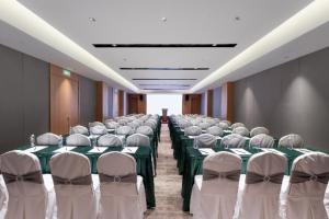 a conference room with green tables and white chairs at JOYCHENG Hotel Wuhan Hanyang Avenue Guobo in Han-yang-hsien