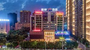 una ciudad iluminada por la noche con muchos edificios altos en Echarm Plus Hotel Nanning Convention and Exhibition Center Medical University, en Nanning