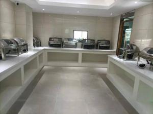 una sala de espera con una fila de lavabos y espejos en Echarm Plus Hotel Nanning Convention and Exhibition Center Medical University, en Nanning