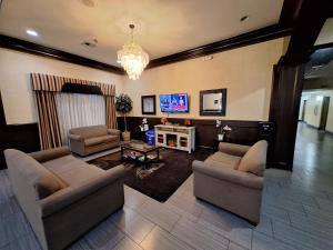 a living room with two couches and a tv at Trident Inn & Suites New Orleans in New Orleans