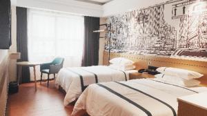 um quarto de hotel com duas camas e uma cadeira em City Comfort Inn Chenzhou Wuling Square em Chenzhou
