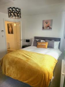 a bedroom with a large bed with a yellow blanket at City Vibes Getaway in Leeds