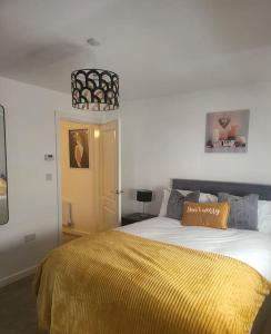 a bedroom with a large bed with a yellow blanket at City Vibes Getaway in Leeds