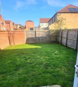 a backyard with a fence and a grass yard at City Vibes Getaway in Leeds