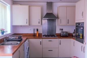 a kitchen with white cabinets and a stove top oven at City Vibes Getaway in Leeds