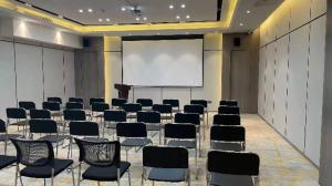 sala konferencyjna z krzesłami i ekranem projekcyjnym w obiekcie Echarm Hotel Yantai Wuzhou International w mieście Fushan