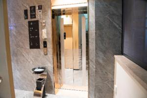 a bathroom with a shower with a sink and a mirror at City Comfort Inn Baise High-speed Railway Station Exit in Baise