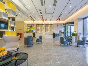 a lobby with chairs and tables in a building at Echarm Hotel Wuhu Wanzhi East Lake Yingbin Avenue in Liangzhongchang