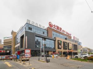 duży budynek z parkingiem przed nim w obiekcie Echarm Hotel Wuhu Wanzhi East Lake Yingbin Avenue w mieście Liangzhongchang