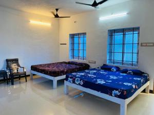 een slaapkamer met 2 bedden, een stoel en ramen bij Reho Resort 
