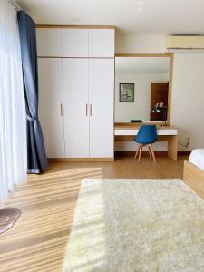 濠莊的住宿－Mimi Coastar Villa，一间卧室配有一张床和一张带蓝椅的书桌