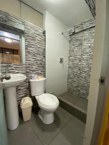 een badkamer met een toilet, een wastafel en een douche bij Wayra Hotel in Huaraz