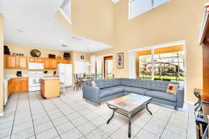 a living room with a blue couch and a table at Near Disney 7BR Home - Pool Hot Tub Games Room in Kissimmee