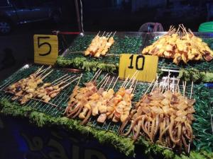 a bunch of food on tongs on a grill at Fun-D City View in Khon Kaen