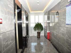 a hallway with a potted plant in a building at Super 8 Hotel Urumqi West Wuyi Road in Ürümqi