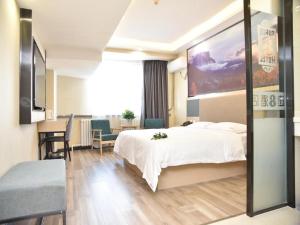 a hotel room with a large bed and a table at Super 8 Hotel Urumqi West Wuyi Road in Ürümqi