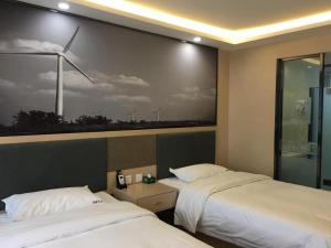 a room with two beds and a painting of a wind turbine at Super 8 Hotel Urumqi West Wuyi Road in Ürümqi +3 photos